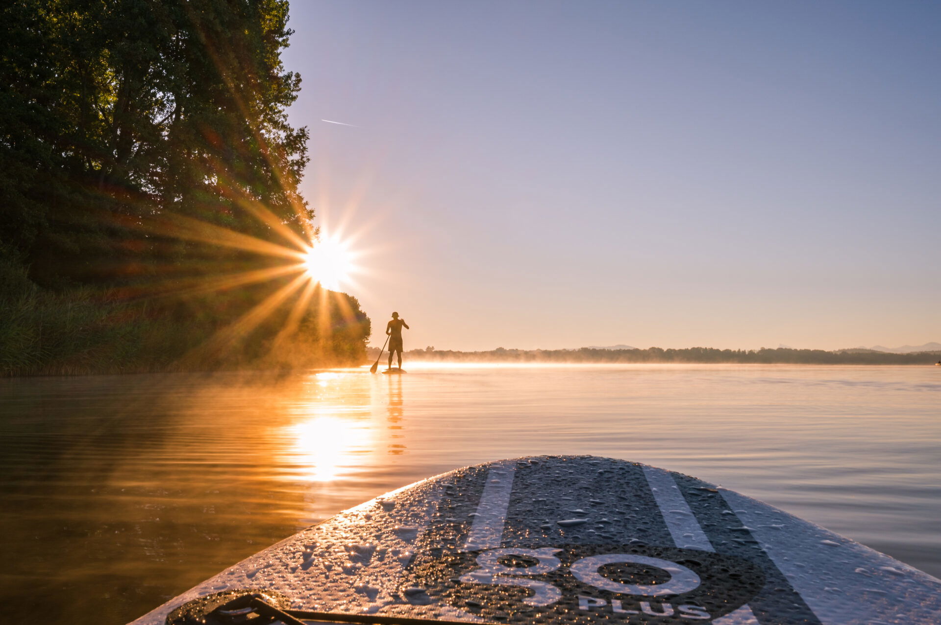 Stand-Up Paddle im Wasser während dem Sonnenuntergang.