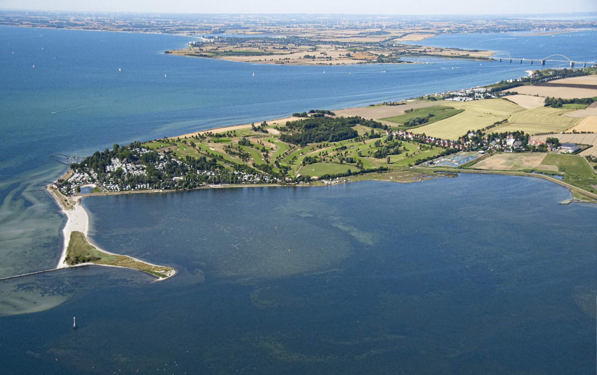 Die grüne Insel Fehmarn von blauem Wasser umgeben.