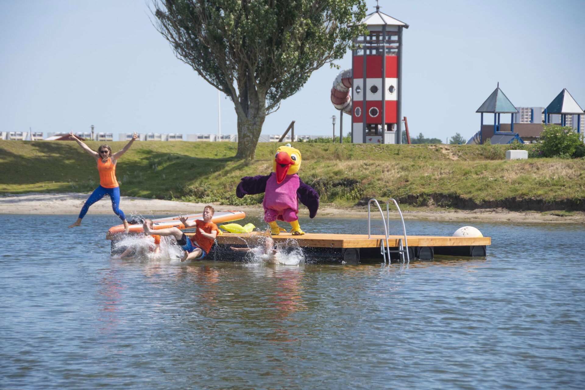 Freudige Menschen am planschen vor einer schwimmenden Insel im Zeller See vor einem Spielplatz